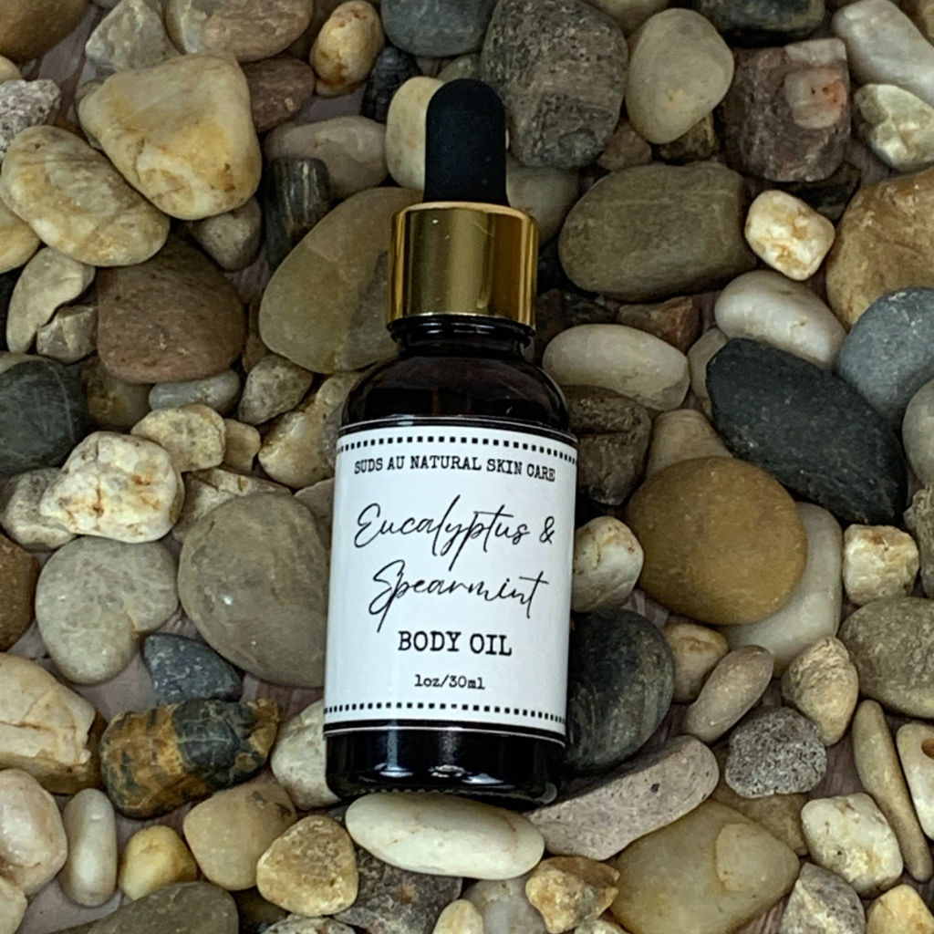 Spearmint and Eucalyptus scented body oil on top of rocks